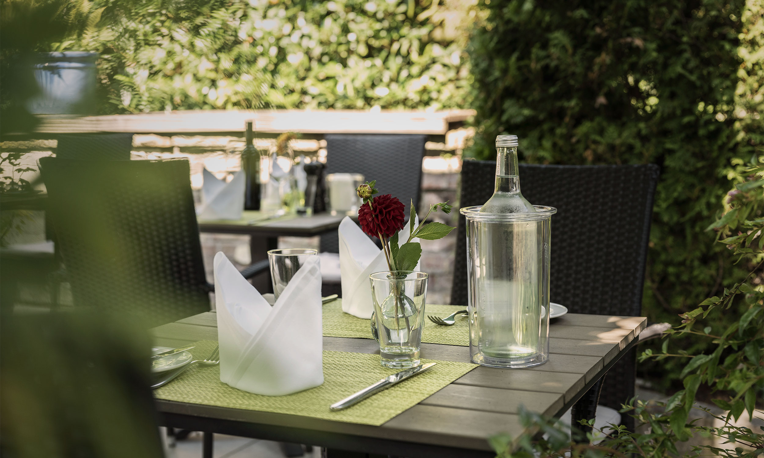 Ein gedeckter Tisch auf der grünen Aussenterrasse des Restaurants Die Krone Homberg in Ratingen